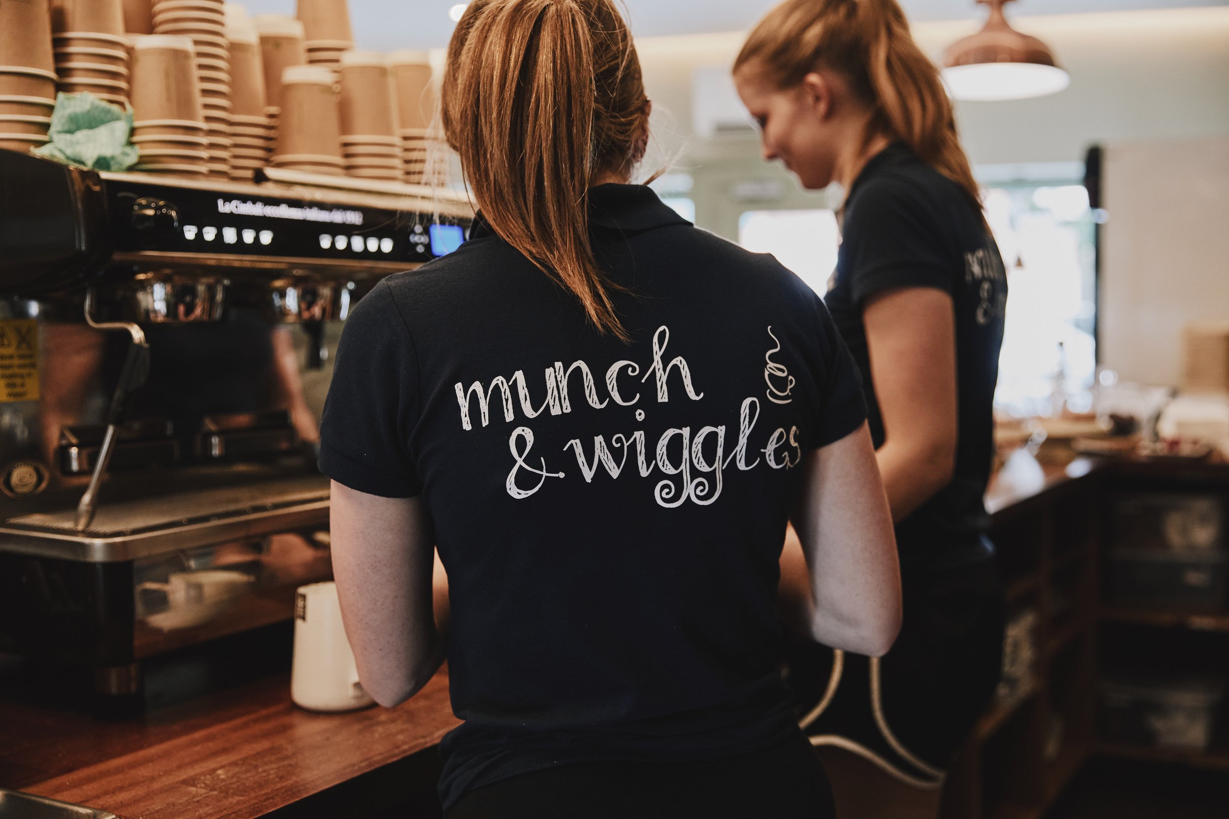 Expert baristas working at their custom-made coffee counter in Munch & Wiggles, Oxshott